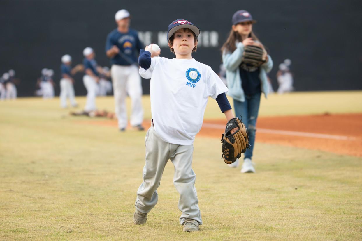 Will Clark, 7 years old with Down syndrome, practices tossing a ball before he throws the first pitch during the WES's Game match in The Ball Park at Jackson, in Jackson, Tenn., on Thursday, March 21, 2024.