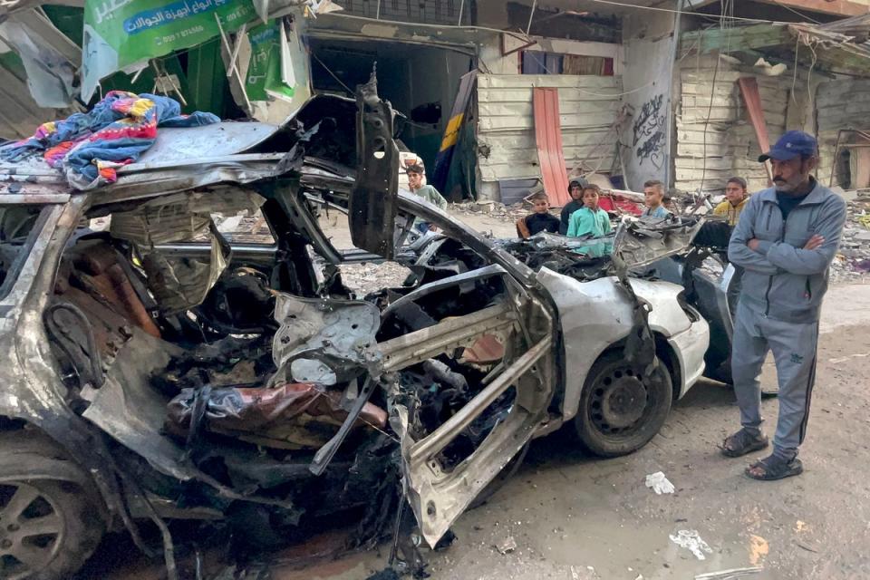 Onlookers check the car in which three sons of Hamas leader Ismail Haniyeh were reportedly killed in an Israeli air strike in al-Shati camp (AFP via Getty Images)