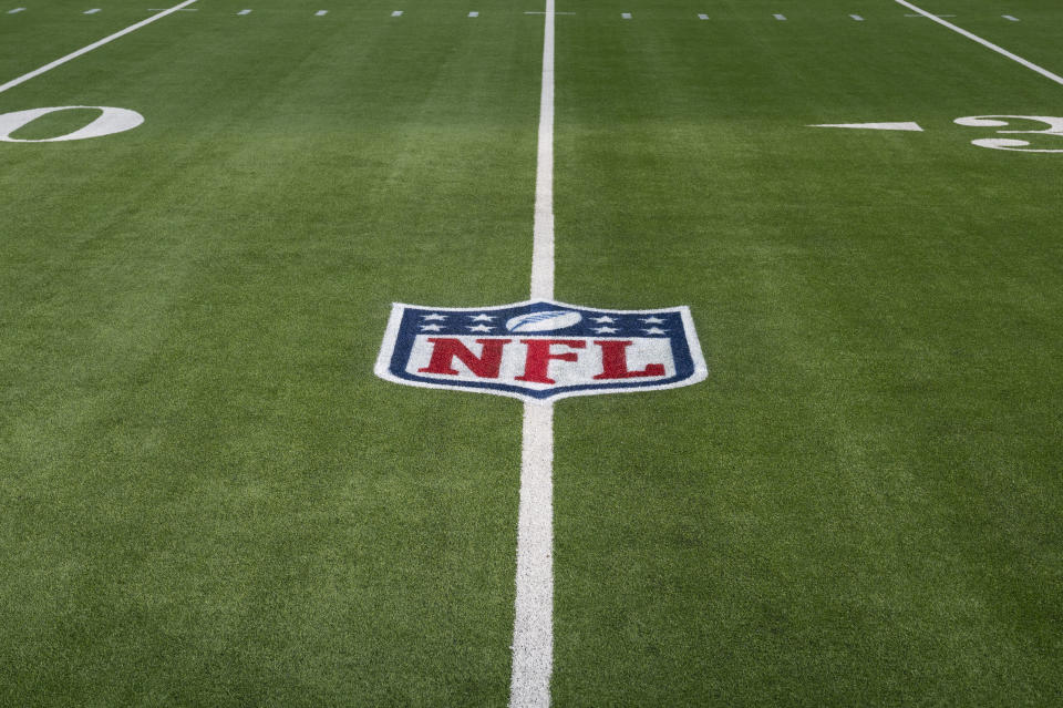 FILE - The NFL logo is shown on the artificial turf at So Fi Stadium in Inglewood, Calif. Dec. 5, 2021. The NFL Players Association wants the league to switch all its fields to natural grass, calling it the easiest decision the NFL can make to protect players. (AP Photo/John McCoy, File)