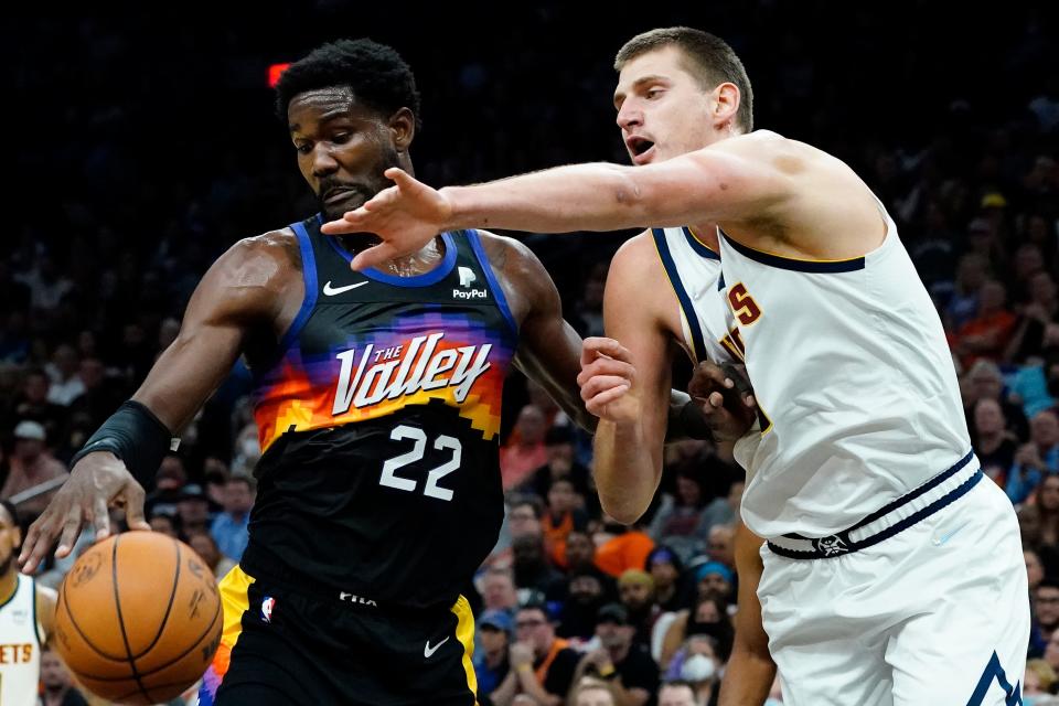 Denver Nuggets center Nikola Jokic (15) battles Phoenix Suns center Deandre Ayton (22) for the ball during the first half of an NBA basketball game, Wednesday, Oct. 20, 2021, in Phoenix. (AP Photo/Matt York).