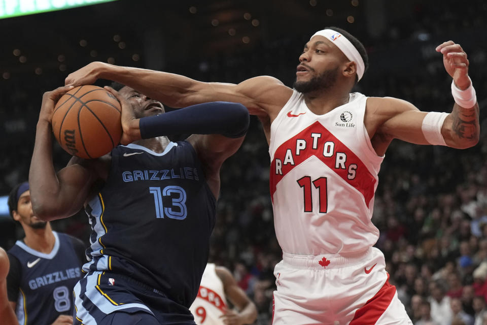 Toronto Raptors forward Bruce Brown (11) fouls Memphis Grizzlies forward Jaren Jackson Jr. (13) during first-half NBA basketball action in Toronto, Monday, Jan. 22, 2024. (Nathan Denette/The Canadian Press via AP)