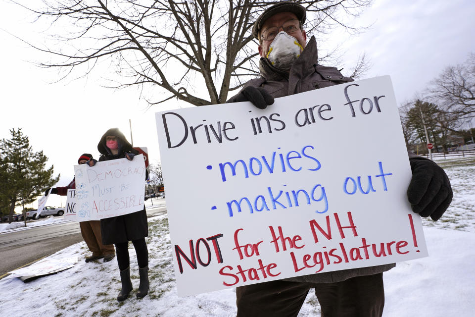 Dennis Jakubowski, of Loudon, N.H., right, protests as state representatives arrive for an outdoor meeting of the New Hampshire House of Representatives in a parking lot, due to the COVID-19 virus outbreak, at the University of New Hampshire Wednesday, Jan. 6, 2021, in Durham, N.H. (AP Photo/Charles Krupa)