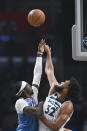 Los Angeles Clippers guard Reggie Jackson, left, shoots over Minnesota Timberwolves center Karl-Anthony Towns during the first half of an NBA basketball game in Los Angeles Saturday, Nov. 13, 2021. (AP Photo/Kyusung Gong)