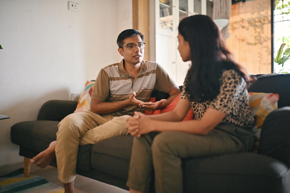 A man and woman talking on the sofa