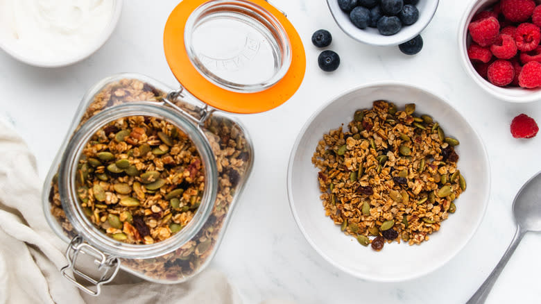 Pumpkin seed granola in jar and bowl with berries