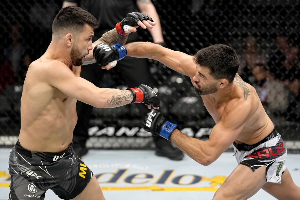 LAS VEGAS, NEVADA - DECEMBER 11: Dominick Cruz punches Pedro Munhoz of Brazil in their bantamweight bout during the UFC 269 on December 11, 2021 in Las Vegas, Nevada. (Photo by Jeff Bottari/Zuffa LLC)