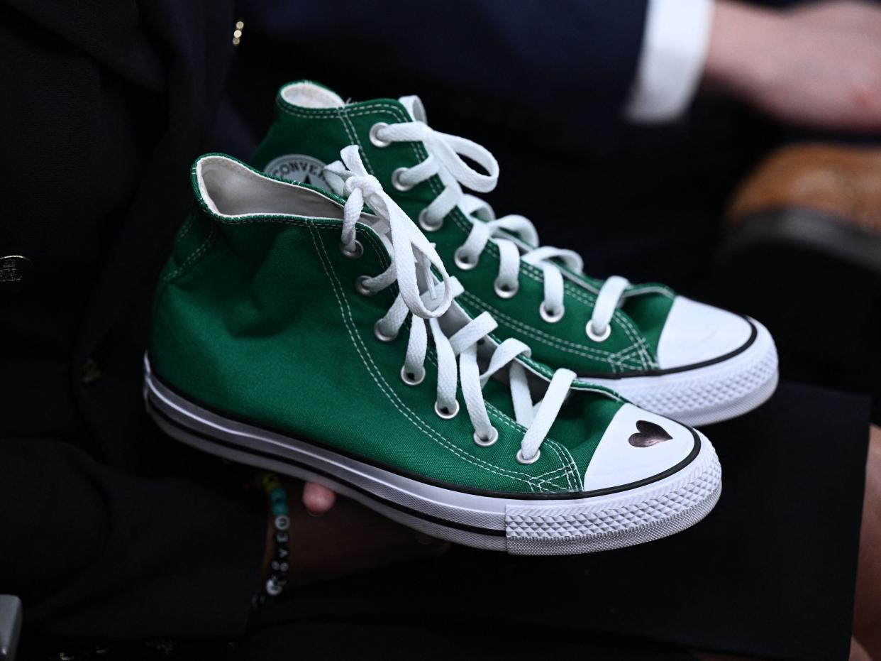 An image of green high top shoes with a heart drawn on the right, worn by a nine-year-old killed at the Robb Elementary School.