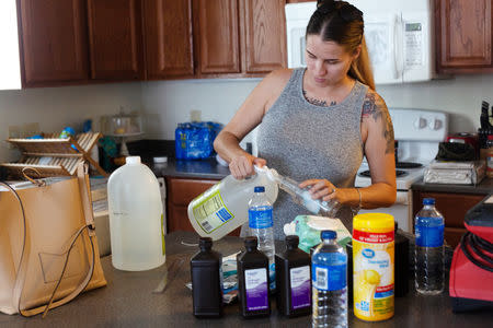 Jennifer Maher, pregnant in her third trimester, prepares cleaning supplies in an attempt to clean up mold after suffering severe damage to her home post-Hurricane Florence at Marine Corps Base Camp Lejeune, North Carolina, U.S., September 27, 2018. REUTERS/Andrea Januta