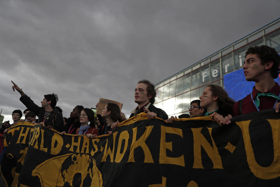 People shout slogans during a march organized by the Fridays for Future international movement of school students outside of the COP25 climate talks congress in Madrid, Spain, Friday, Dec. 13, 2019. The United Nations Secretary-General has warned that failure to tackle global warming could result in economic disaster. (AP Photo/Manu Fernandez)