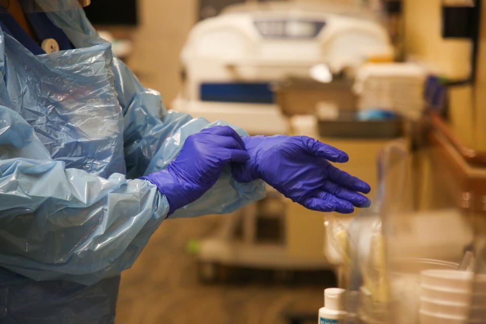 Nurse Joanne Young puts on personal protective equipment, or PPE, in a hallway of the COVID-19 unit at Eisenhower Health on Wednesday, June 24, 2020 in Rancho Mirage, Calif.