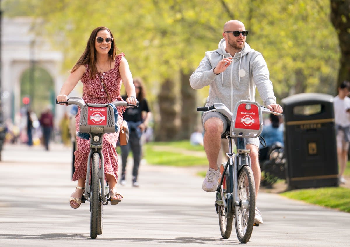 Cyclists ride Santander hire bikes in Hyde Park (PA)