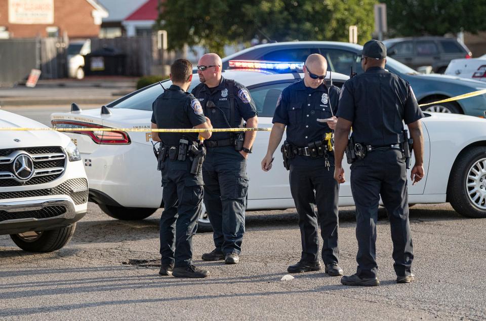 Police and investigators work the scene where one person was found fatally shot and one was injured at around 5 a.m. on Saturday, Aug. 14, 2021, in a parking lot near the intersection of West 38th Street and Lafayette Road in Indianapolis. 