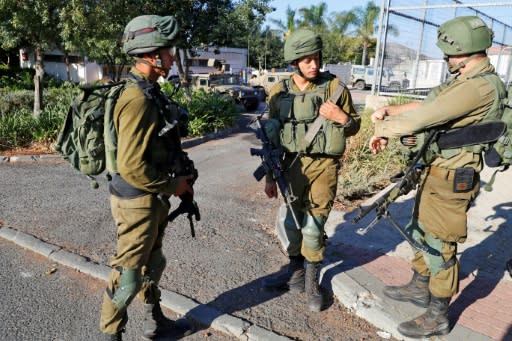 Israeli soldiers stand guard in the northern town of Avivim, close to the border with Lebanon