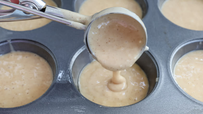 ladling batter into muffin tin