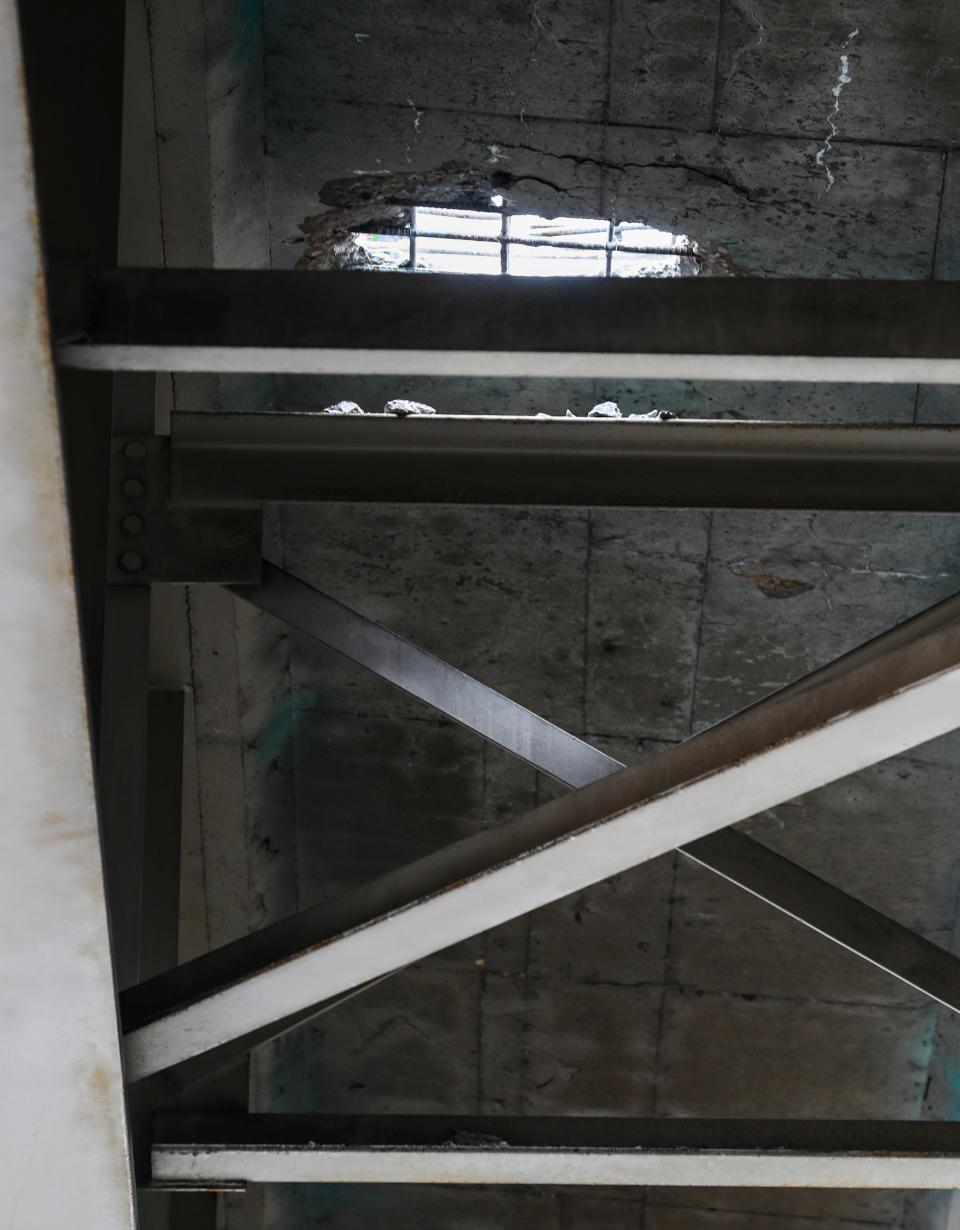 Chunks of concrete sit on a metal girder underneath a large pothole on Interstate 65 near Hospital Curve in downtown Louisville Wednesday. Tthe Kentucky Transportation Cabinet shut down part of Interstate 65 Southbound downtown to repair it. May 22, 2024
(Credit: Matt Stone/Courier Journal)