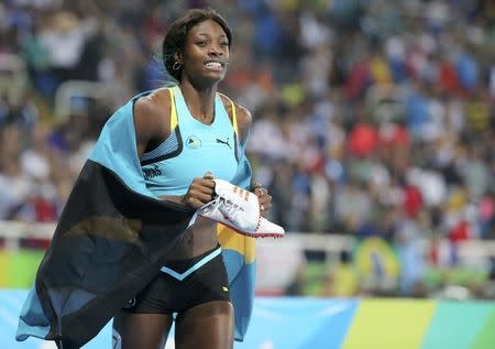 2016 Rio Olympics - Athletics - Final - Women's 400m Final - Olympic Stadium - Rio de Janeiro, Brazil - 15/08/2016. Shaunae Miller (BAH) of Bahamas holds her shoes in her hands as she celebrates after winning the gold medal. REUTERS/Sergio Moraes