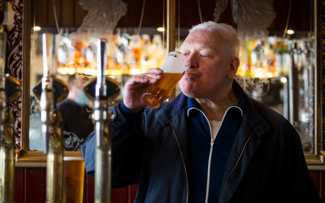 A customer at the Waverley, Edinburgh, enjoys a drink at the bar -  Jane Barlow/PA