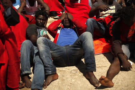 African immigrants lie on the ground after arriving on a rescue ship at the southern Spanish port of Tarifa, near Cadiz, southern Spain August 12, 2014. REUTERS/Jon Nazca