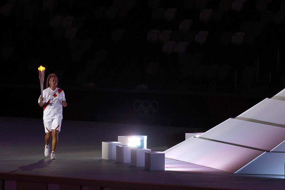 <p>TOKYO, JAPAN - JULY 23: Naomi Osaka of Team Japan carries the Olympic torch towards the Olympic cauldron during the Opening Ceremony of the Tokyo 2020 Olympic Games at Olympic Stadium on July 23, 2021 in Tokyo, Japan. (Photo by Maddie Meyer/Getty Images)</p> 