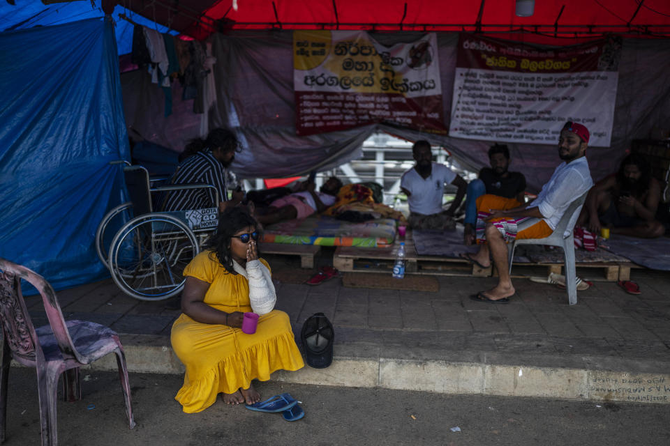 Protesters sit at their protest site in the morning in Colombo, Sri Lanka, Thursday, July 21, 2022. Sri Lanka's prime minister Ranil Wickremesinghe was elected president Wednesday by lawmakers who opted for a seasoned, veteran leader to lead the country out of economic collapse, despite widespread public opposition. (AP Photo/Rafiq Maqbool)