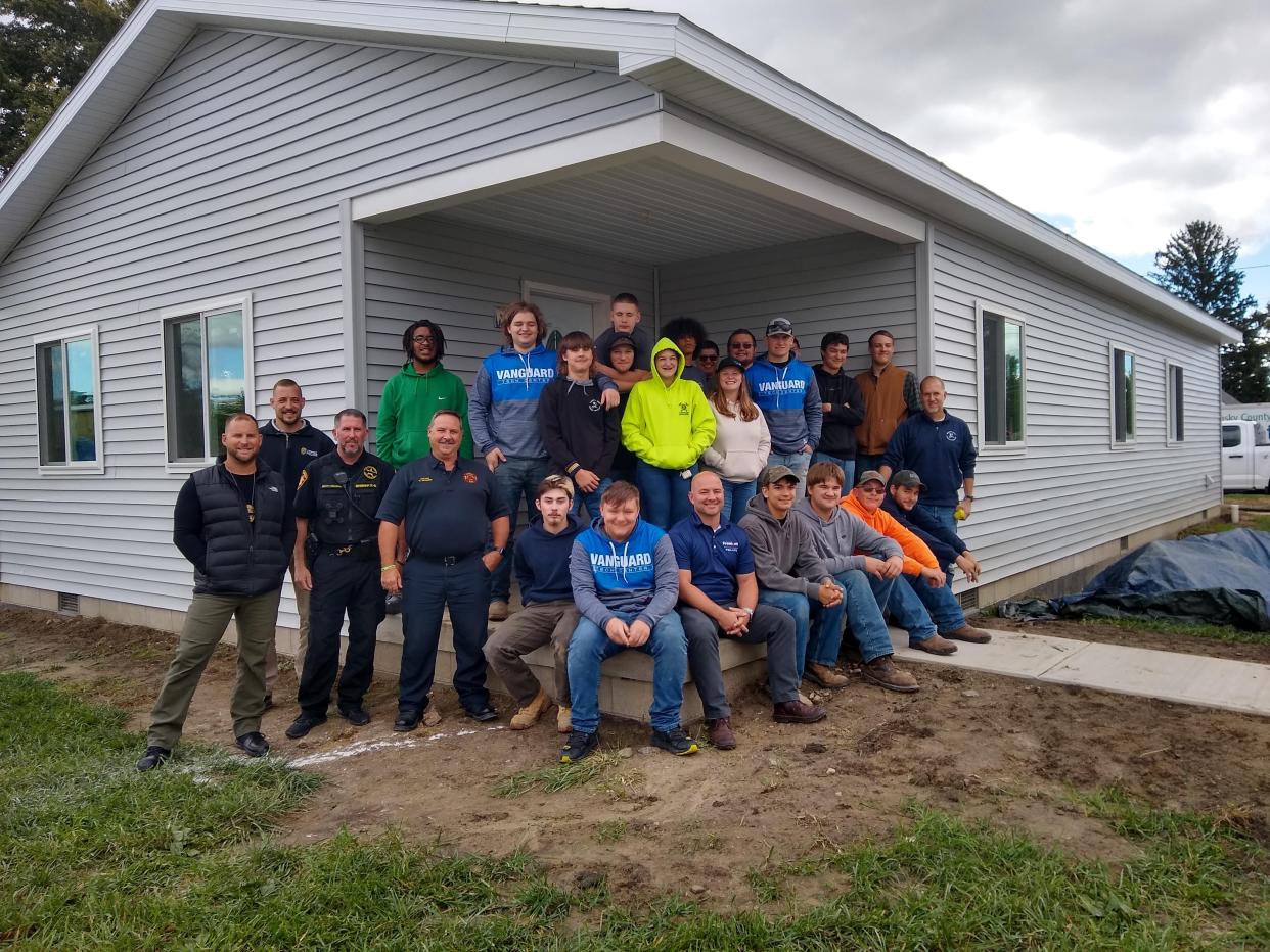 Habitat for Humanity volunteers and workers stand next to a build for the Sandusky County organization.