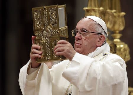 Pope Francis holds Book of the Gospels as he leads the Easter vigil mass in Saint Peter's basilica at the Vatican, April 15, 2017. REUTERS/Max Rossi