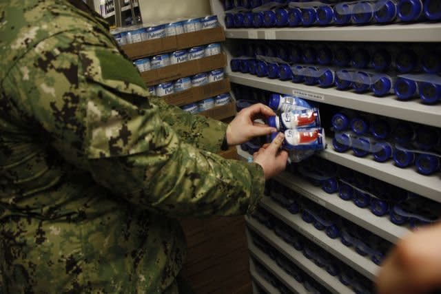 A guard displays cans of Ensure used to force feed detainees at Guantanamo.