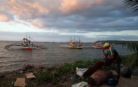 A fisherman look at the fishing boats that just returned from disputed Scarborough Shoal, as they are docked at the coastal village of Cato in Infanta, Pangasinan in the Philippines, October 31, 2016. REUTERS/Erik De Castro