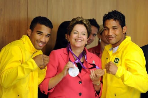 Brazilian President Dilma Rousseff (C) poses with Olympic boxers Yamaguchi Falcao (R) and Esquiva Falcao (L) and their medals. Rousseff received the Olympic flag on Tuesday as the competition's world governing body warned that the country had to "work harder" ahead of the Rio 2016 Summer Games