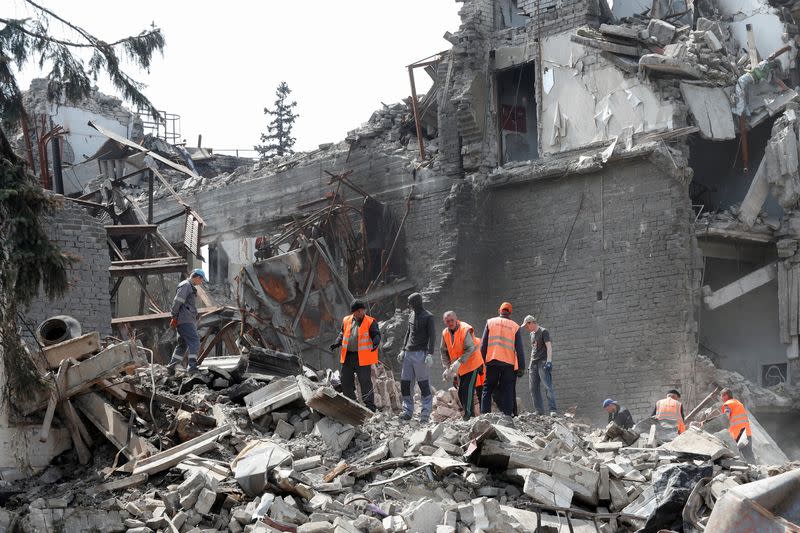 FILE PHOTO: People remove the debris of a theatre building in Mariupol