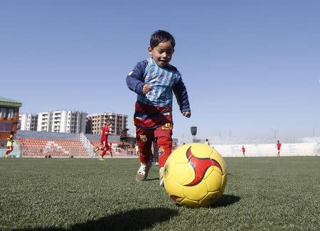 Five year-old Murtaza Ahmadi, wears Barcelona's star Lionel Messi shirt made of a plastic bag , as he plays football at the Afghan Football Federation headquarter in Kabul, Afghanistan February 2, 2016. REUTERS/Omar Sobhani