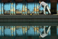 <p>A staff member sweeps the poolside of the Men’s First Class pool at Victoria Baths, which opened for the first time in over 20 years for a one-off public swimming event, May 14, 2017, in Manchester, England. (Photo: Anthony Devlin/Getty Images) </p>