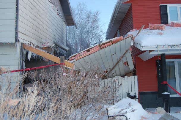 The lower right wall of the home in Yellowknife leaning on a neighbouring home after the blast.