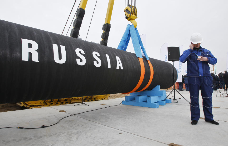 FILE - A Russian construction worker speaks on a mobile phone during a ceremony marking the start of Nord Stream pipeline construction in Portovaya Bay some 170 kms (106 miles) north-west from St. Petersburg, Russia on April 9, 2010. Germany’s new government has found itself facing a mountain of problems in relation to Russia since taking office last month. Germany’s foreign minister made a flying visit to Washington on Wednesday to highlight the common stance between her government and the United States on Russia. (AP Photo/Dmitry Lovetsky, File)