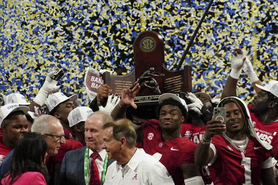 Alabama quarterback Jalen Milroe (4) center and the team holds up the championship trophy after the Southeastern Conference championship NCAA college football game against Georgia in Atlanta, Saturday, Dec. 2, 2023. (AP Photo/John Bazemore)