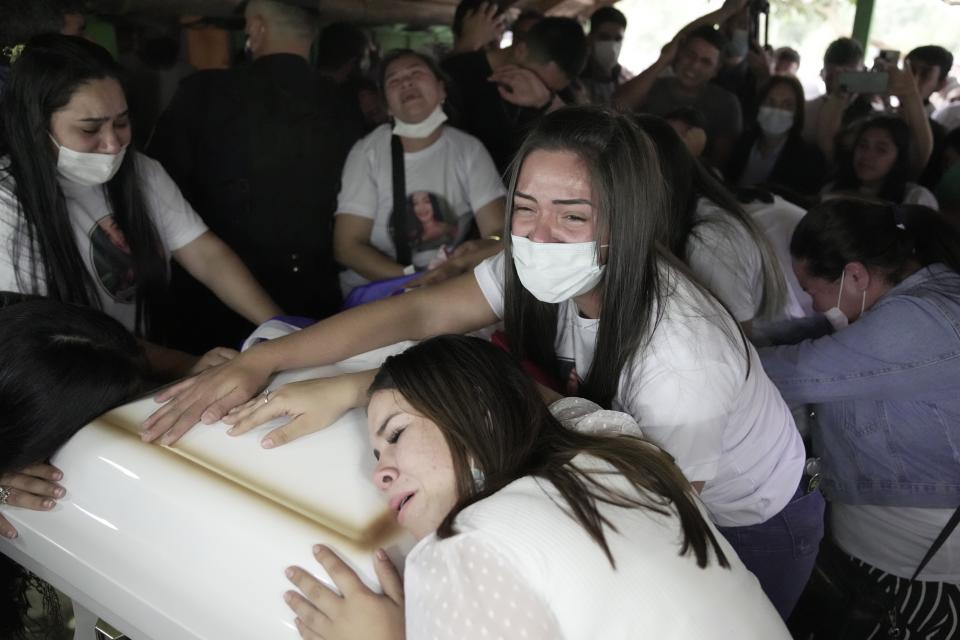 Relatives of Lady Vanessa Luna Villalba mourn over the coffin that contain her remains in her home, in Eugenio Garay, Paraguay, Tuesday, July 13, 2021. Luna Villalba, a nanny employed by the sister of Paraguay's first lady Silvana Lopez Moreira, was among those who died in the Champlain Towers South condominium collapse in Surfside, Florida on June 24. (AP Photo/Jorge Saenz)