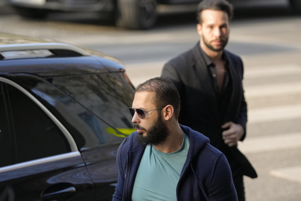 Andrew Tate, front, and his brother Tristan arrive outside the Directorate for Investigating Organized Crime and Terrorism (DIICOT) where prosecutors examine electronic equipment confiscated during the investigation in their case, in Bucharest, Romania, Monday, April 10, 2023. (AP Photo/Andreea Alexandru)