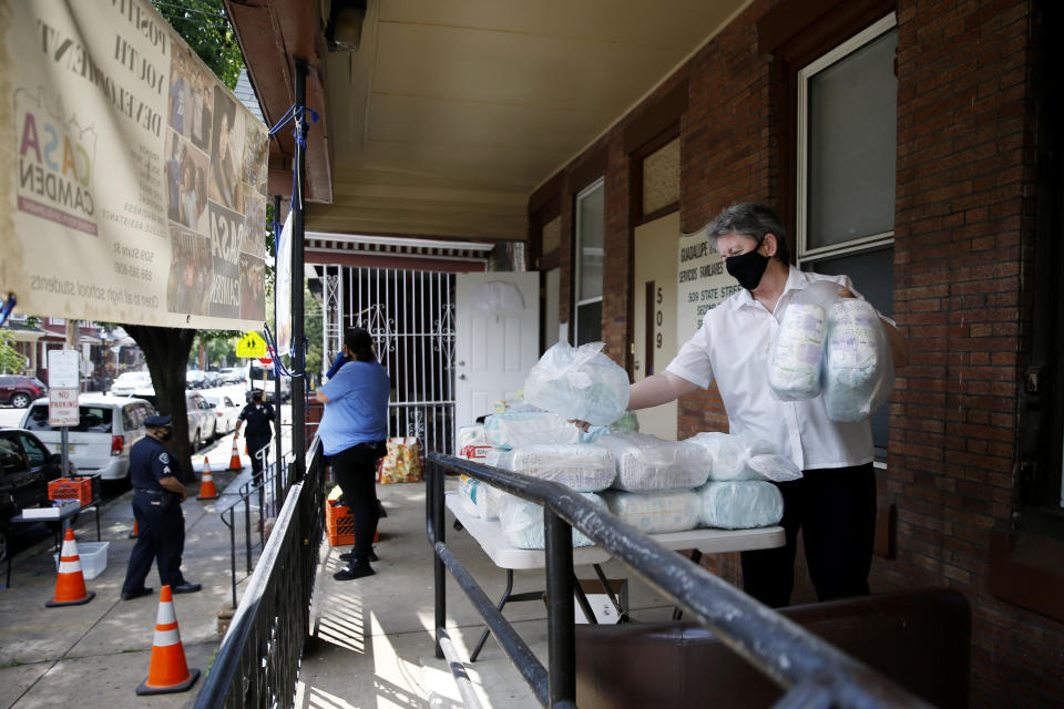 In this June 11, 2020, photo Sister Helen Cole, with Guadalupe Family Services, stacks diapers to distribute to families in Camden, N.J. (AP Photo/Matt Slocum)