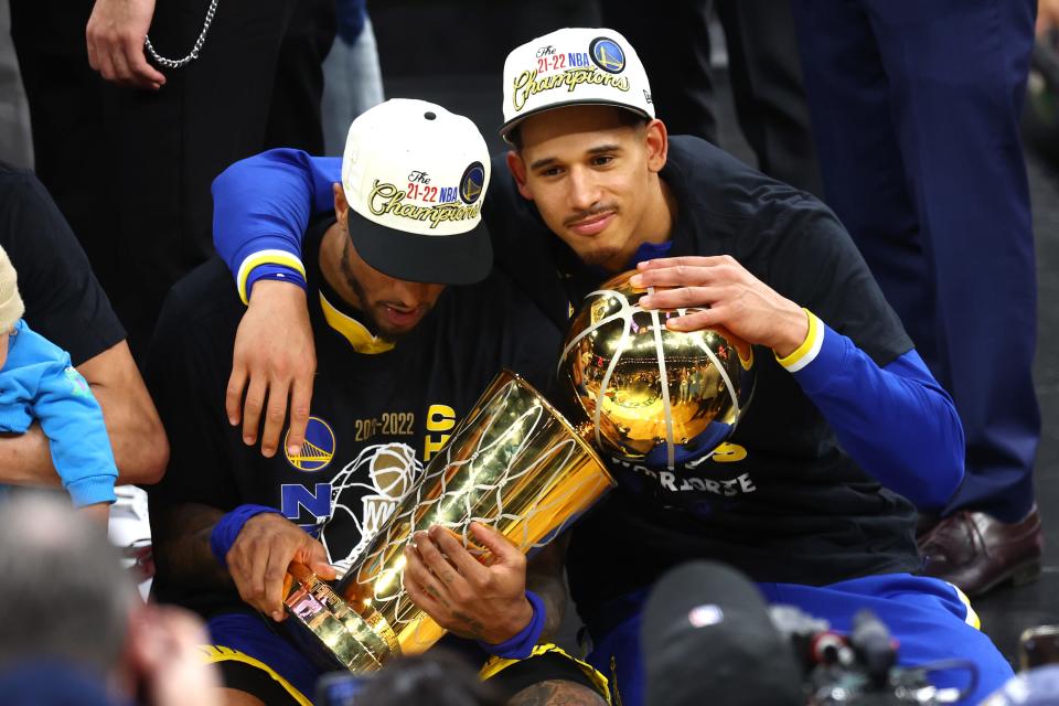 Marquette graduate Juan Toscano-Anderson and former Gary Payton II, a former member of the Milwaukee Bucks, embrace the Larry O'Brien Trophy after the Golden State Warriors defeated the Boston Celtics Thursday night to win the NBA championship.