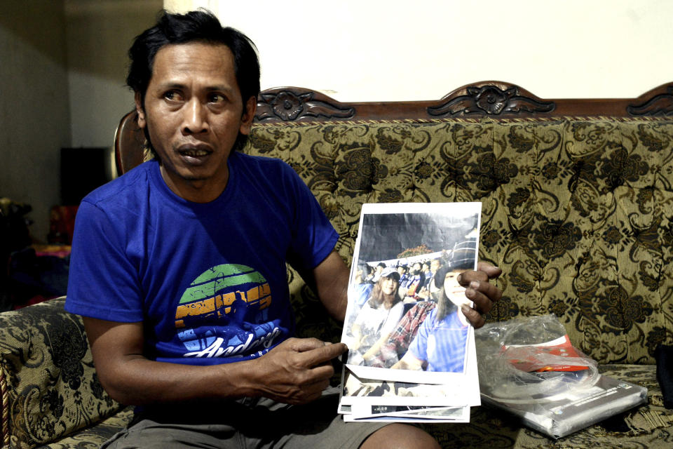 Devi Athok, the father of two teenage girls who died tragically in the October 2022 stampede at the Kanjuruhan stadium in Malang, Indonesia, holds pictures of his daughters during an interview in Malang, East Java province, Saturday, Sept. 30, 2023. The crowd surge was among the world's worst sporting tragedies. Some 43 children died and around 580 people were injured in the incident. (AP Photo/Hendra Permana)