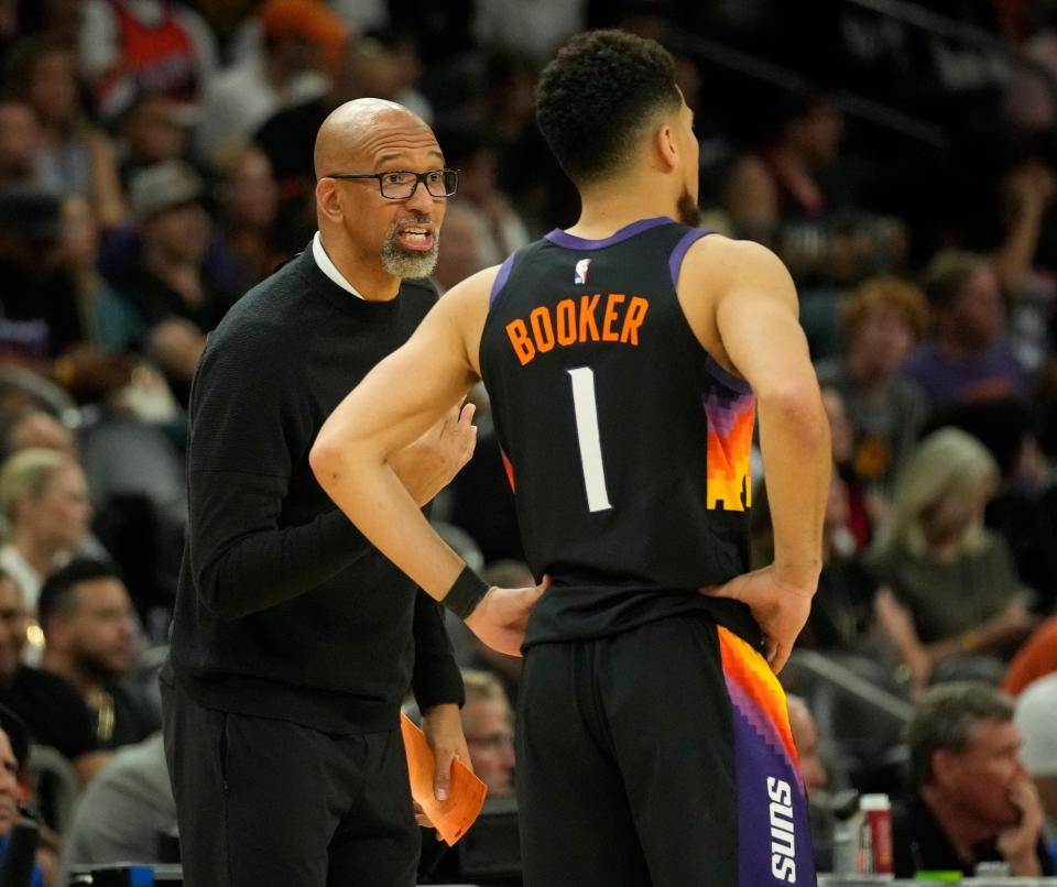 Mar 27, 2022; Phoenix, Arizona, United States;  Phoenix Suns head coach Monty Williams talks with Phoenix Suns guard Devin Booker (1) during the fourth quarter against the Philadelphia 76ers at Footprint Center.