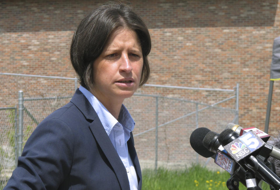 Vermont U.S. Attorney Christina Nolan speaks at a news conference on Wednesday, May 22, 2019 in Newport, Vt., about four men who were indicted in Burlington a multi-million dollar fraud case. She spoke next to a vacant block in downtown Newport where a building was purchased with money from what turned out to be the fraudulent activity, and was torn down. (AP Photo/Wilson Ring)