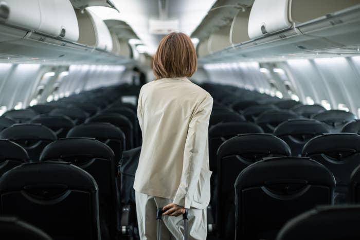 A woman wheels her luggage onto an airplane