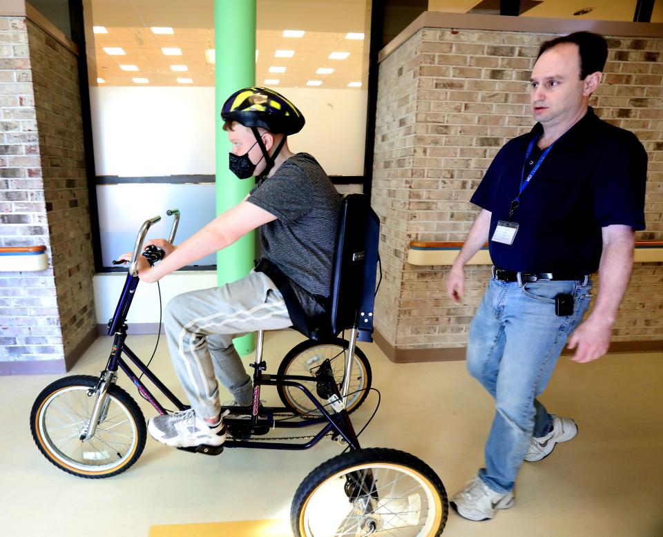 Mark Felsenfeld, PT watches as Zachary Losee rides a bike to help build up his stamina at Blythedale Children's Hospital Feb. 5, 2019.  Zach, a heart transplant recipient wants to become an organ donor advocate after getting a new heart.