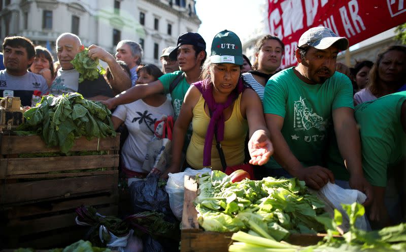 FILE PHOTO: People grab lettuce during a farmers' protest against low prices in Buenos Aires, Argentina, in February 2019
