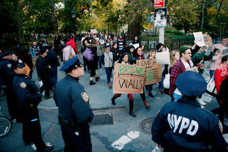 NYPD officers keep an eye on people taking part in a protest against Republican president-elect Donald Trump at the Washington Square park in the neighborhood of Manhattan in New York, U.S., November 11, 2016. REUTERS/Eduardo Munoz