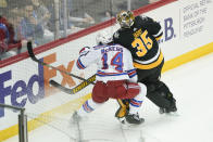 New York Rangers' Greg McKegg (14) runs into Pittsburgh Penguins goaltender Tristan Jarry (35) near the boards during the first period of an NHL hockey game, Saturday, Feb. 26, 2022, in Pittsburgh. (AP Photo/Keith Srakocic)