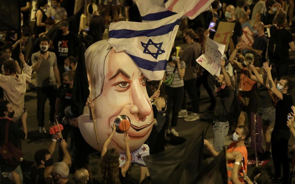 Israelis protest against Israeli prime minister Benjamin Netanyahu outside his residence in Jerusalem - Shutterstock