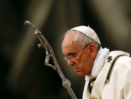 Pope Francis holds a crucifix as he lead the Easter vigil mass in Saint Peter's basilica at the Vatican April 4, 2015. REUTERS/Stefano Rellandini