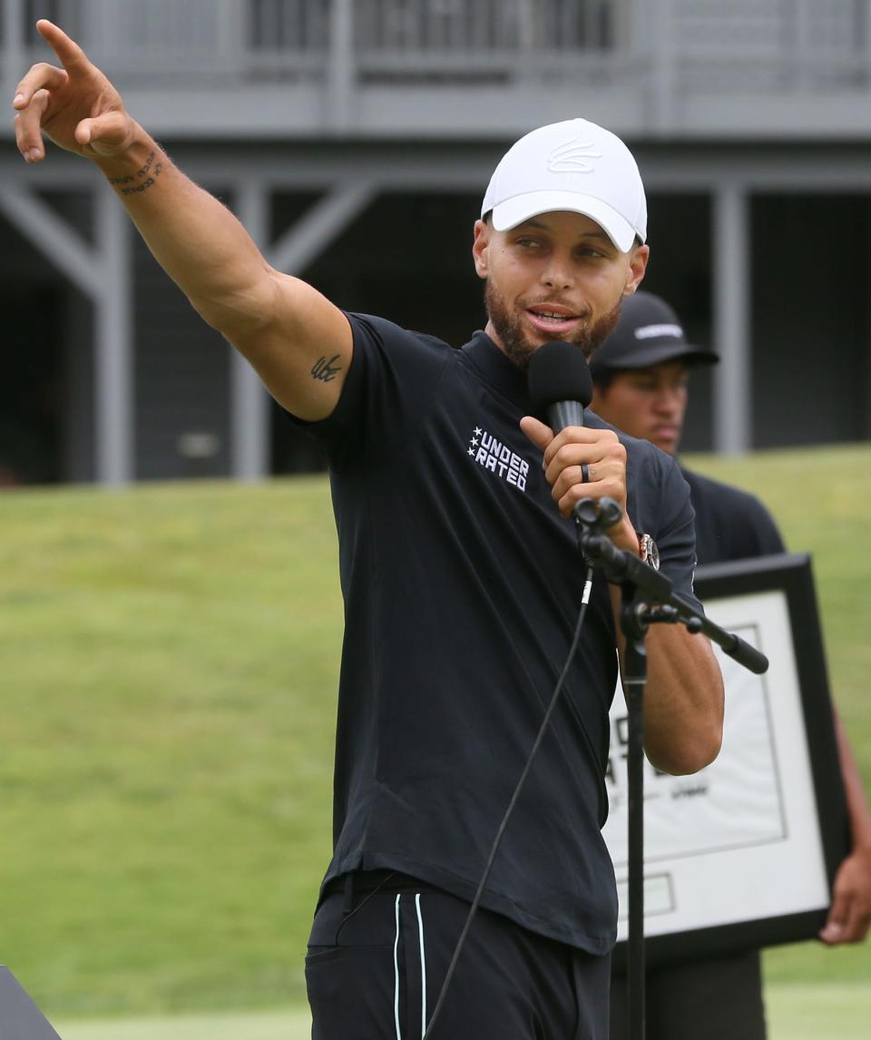 Stephen Curry gestures as he talks about Tiger Wood's  famous shot in the dark on the 18th hole to the Underrated Golf tour players on the South Course at Firestone Country Club in Akron.